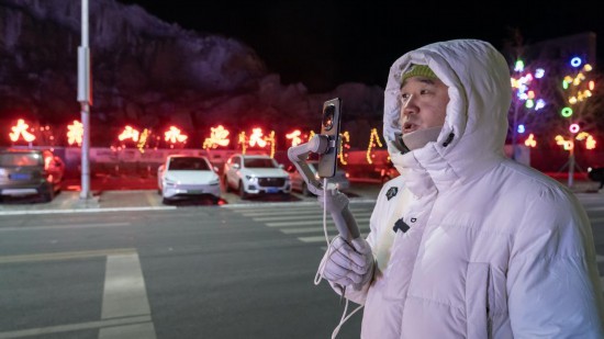 在吉林市阿什哈達(dá)霧凇觀景帶，霧凇播報(bào)員正在直播。新華社記者 李典 攝